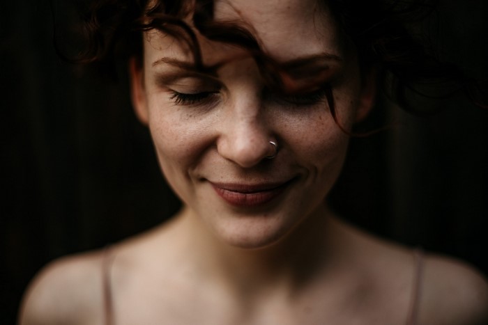 Woman with curly hair and freckles smiling