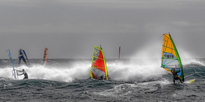 Windsurfers riding waves on a cloudy day