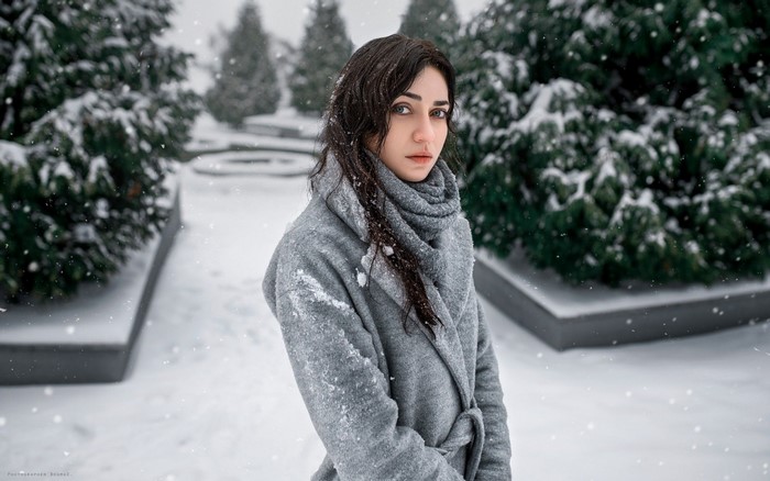 Woman in a gray coat in the snow