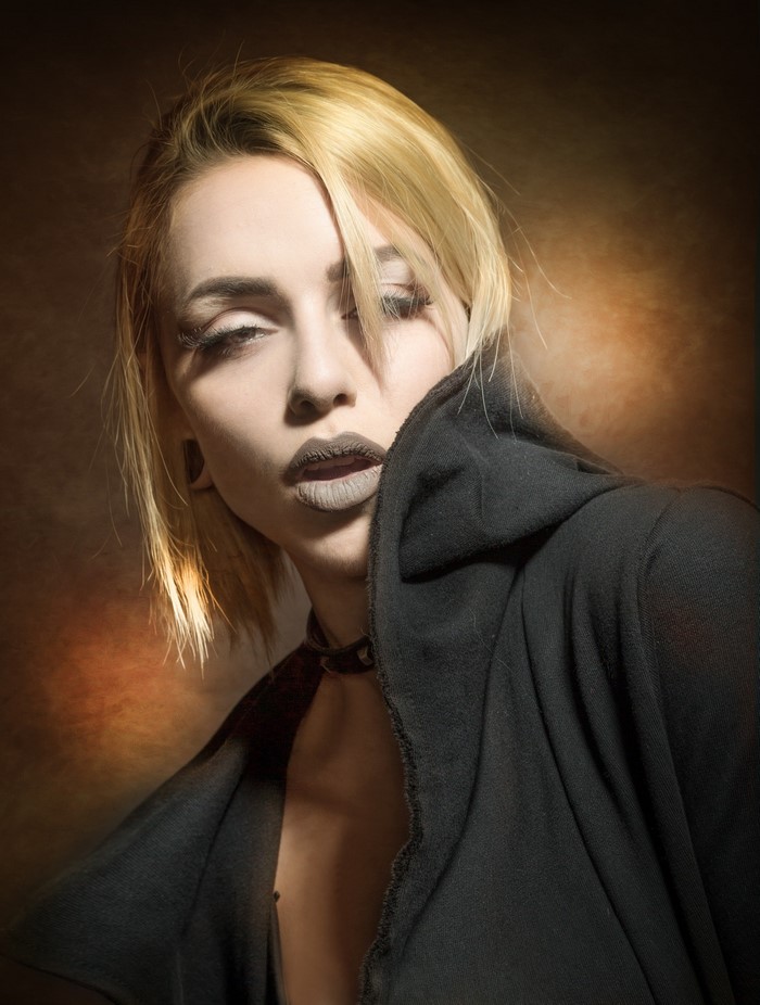 Woman with blonde hair and dark clothing