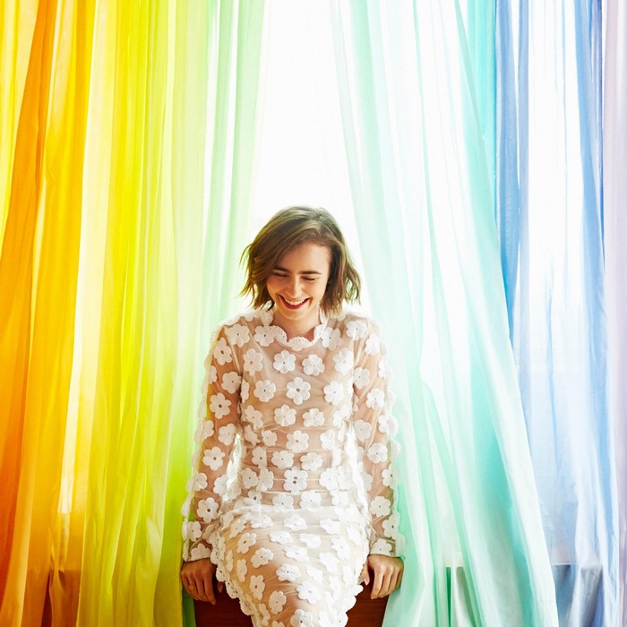 Lily Collins in a floral dress with rainbow curtains