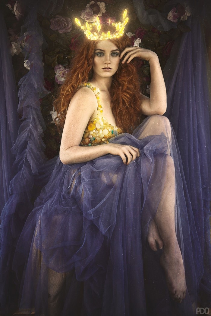 Woman with red hair wearing a crown and gown