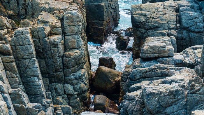 Rocky coastline with waves crashing against boulders