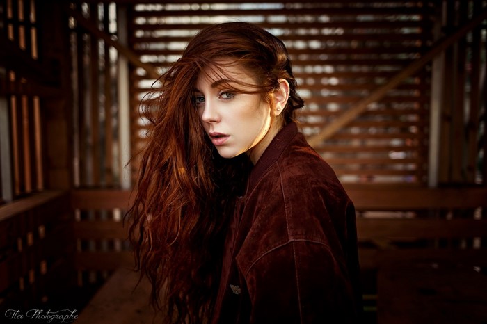 Redhead woman with long hair in a brown jacket