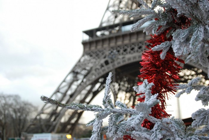 Eiffel Tower with snow-covered Christmas tree and red tinsel