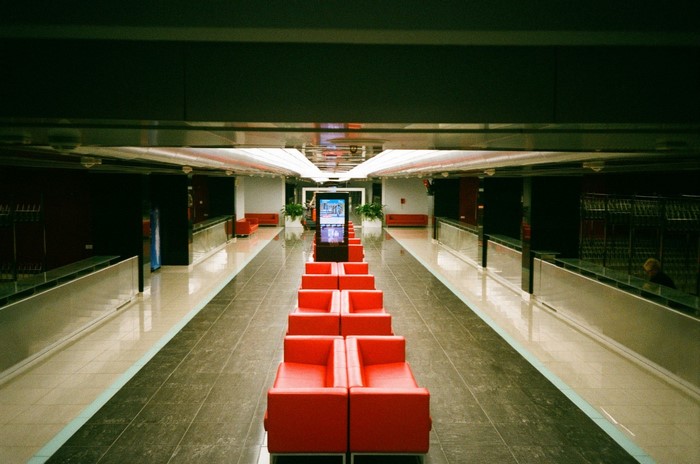 Modern interior with red couches and digital display