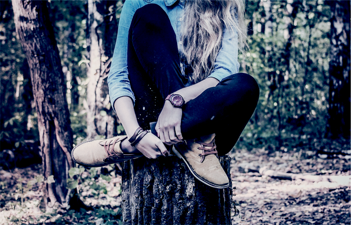 Woman sitting on a tree stump in a forest