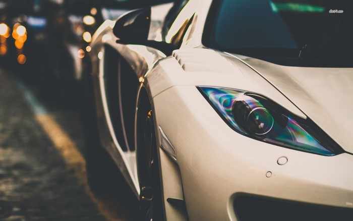White sports car headlight at night