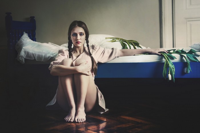 Woman with pigtails and tulips on bed