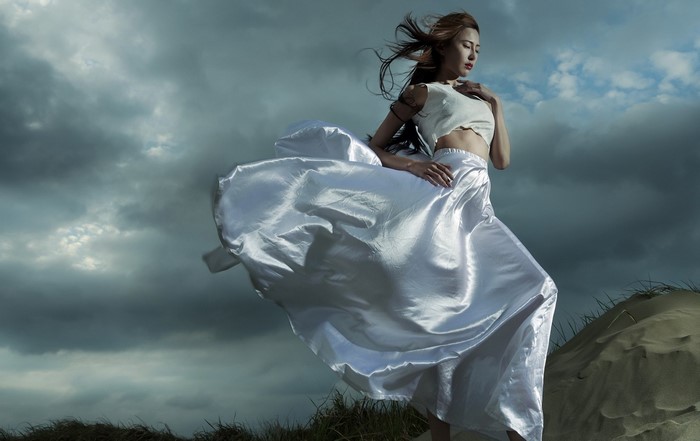 Woman in white dress on sand dunes