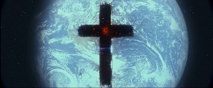 A dark cross hovers over Earth in space