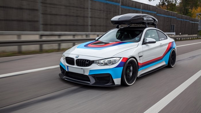 White BMW M4 Coupe with M stripes and roof box