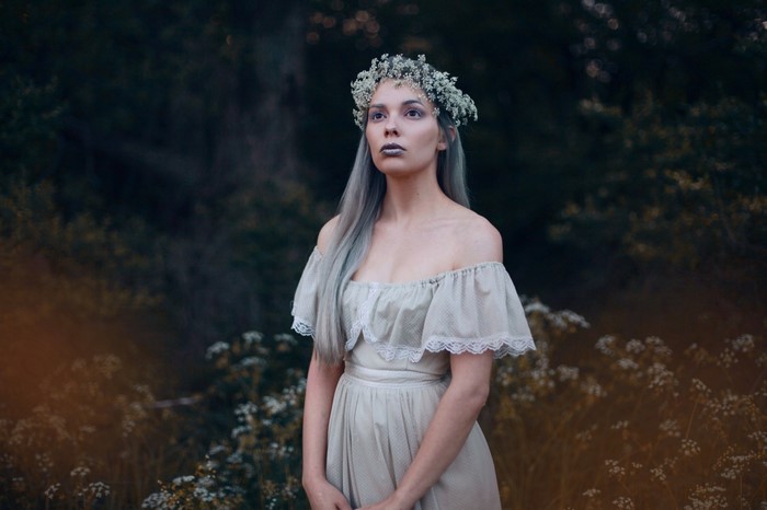 Woman with flower crown and dress in forest