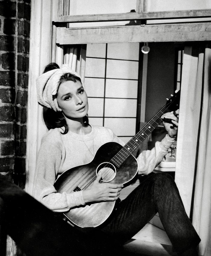 Audrey Hepburn playing guitar