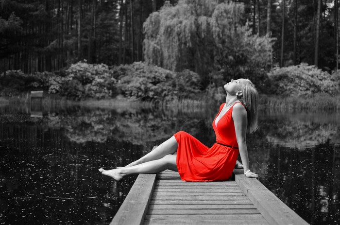 Woman in Red Dress Sitting on Pier by Lake