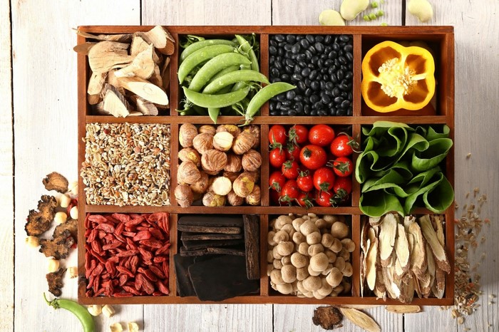 Assortment of dried herbs, beans, vegetables, and grains in a wooden box