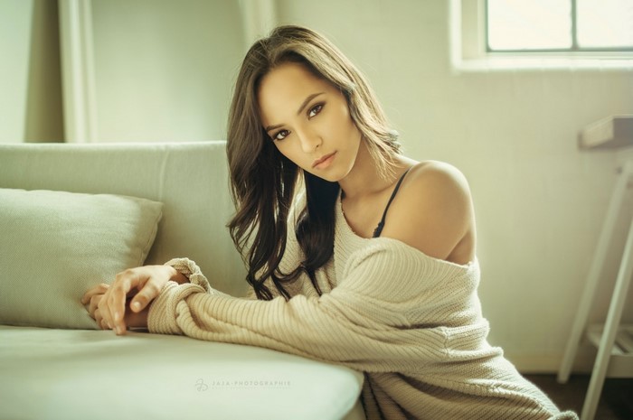 Woman in sweater sitting on couch
