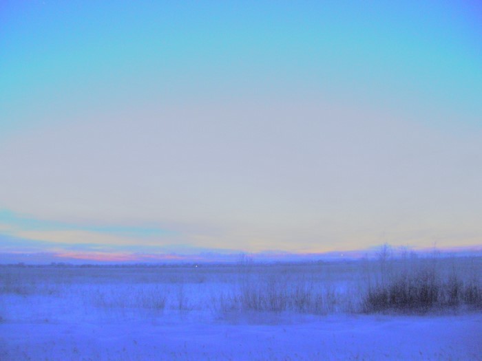 Snowy plain at dusk with colorful sky