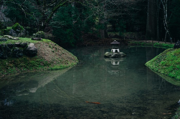 Japanese garden with stone lantern in pond