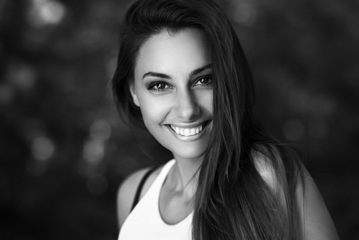 Black and white portrait of a smiling woman with long hair