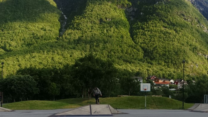 Person skateboarding in front of a mountain in Norway