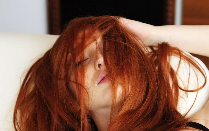 Woman with red hair covering her face