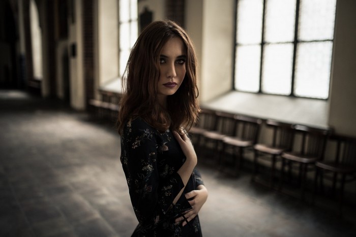 Woman in a dark floral dress in a hall
