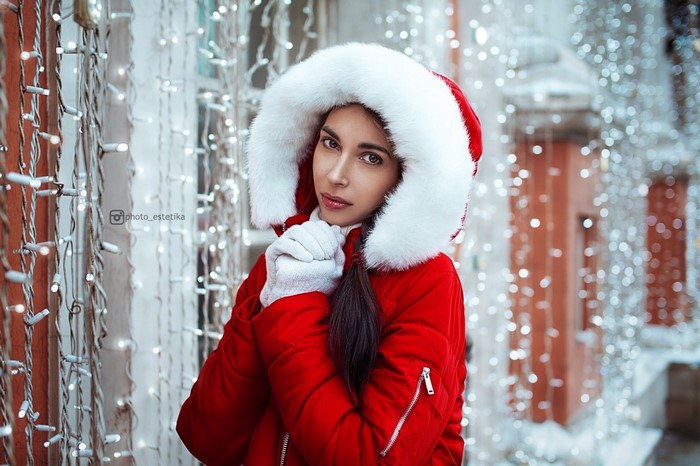 Woman in red Santa-style coat with fur hood and gloves