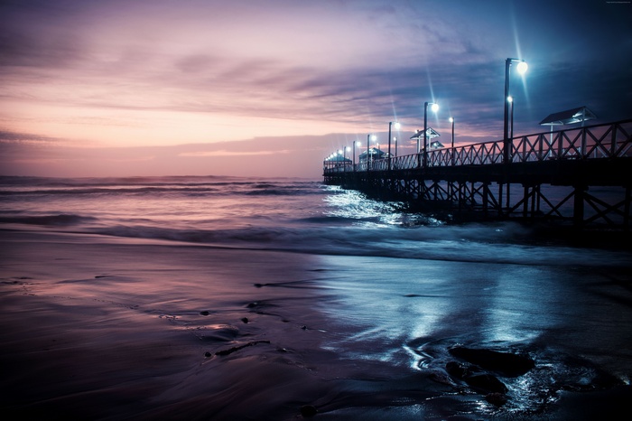 Pier over the ocean at night with lights
