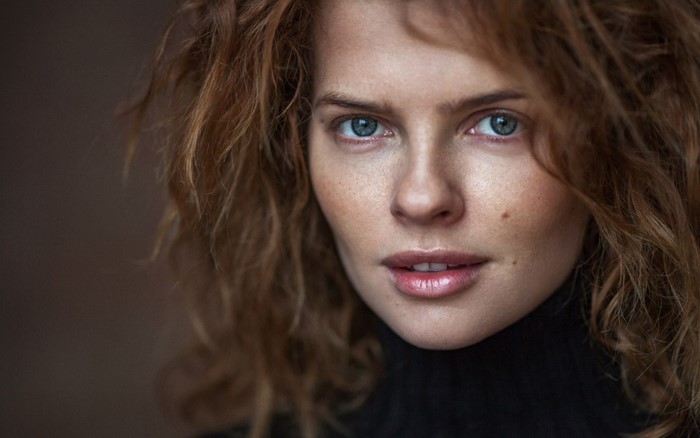 Portrait of a woman with curly red hair and blue eyes