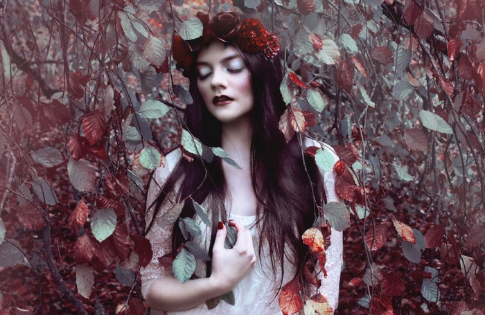 Woman with flower crown in autumn forest