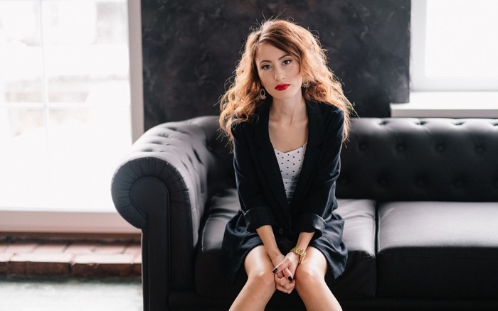 Woman with Red Hair Sitting on Black Couch