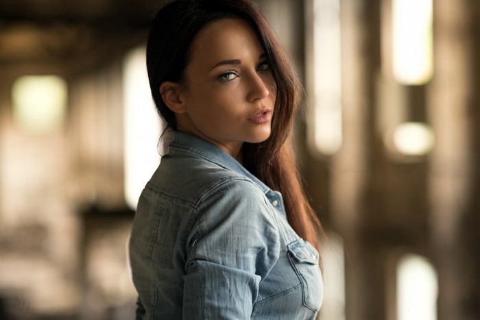 Woman in denim shirt looking over shoulder
