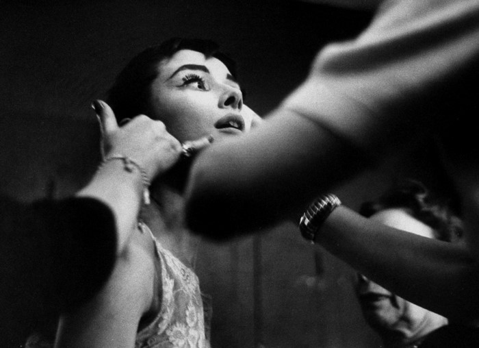 Audrey Hepburn applying makeup backstage