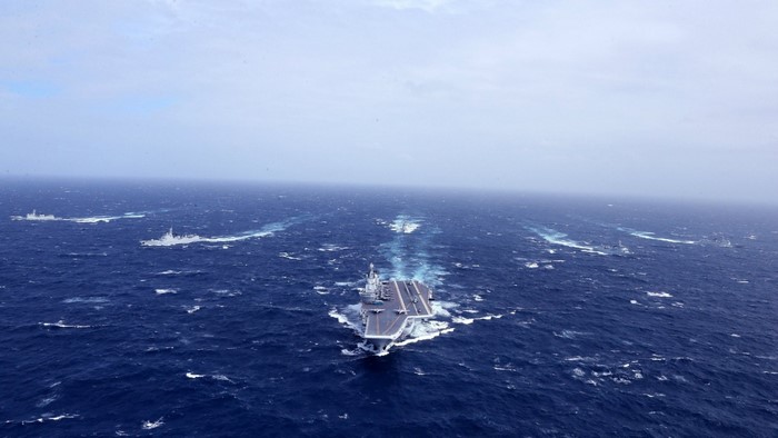 Aircraft carrier and escort ships sailing on the ocean