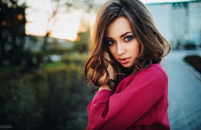 Woman with blue eyes and brown hair in a pink shirt