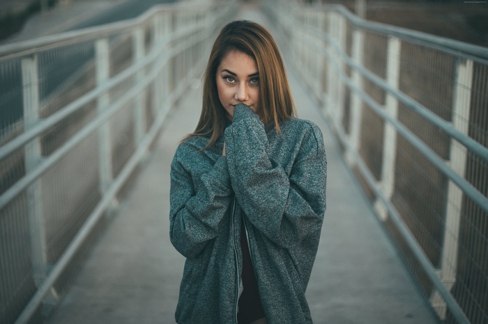 Girl in a grey hoodie on a bridge