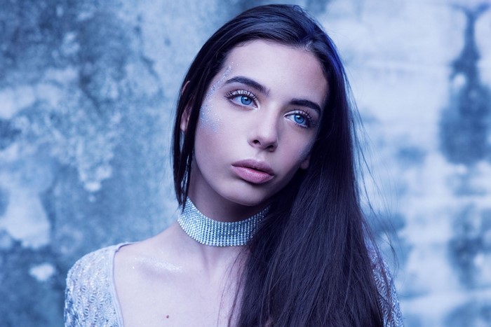 Woman with blue eyes and glitter makeup