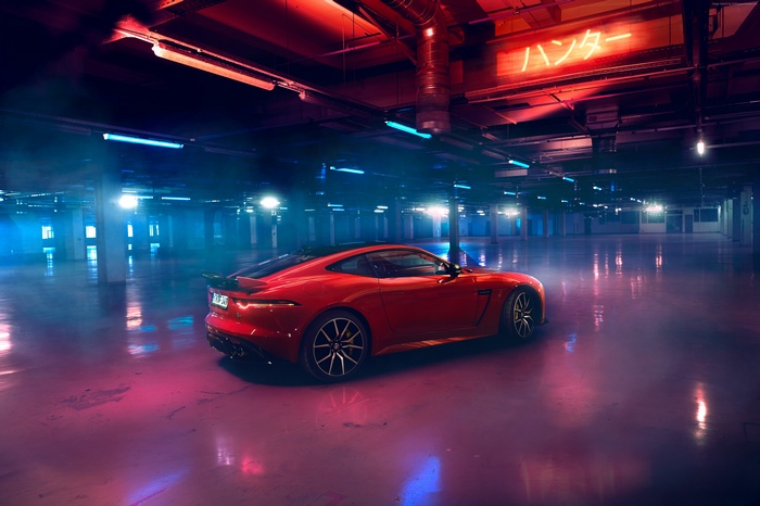 Red Jaguar F-Type in a neon-lit garage