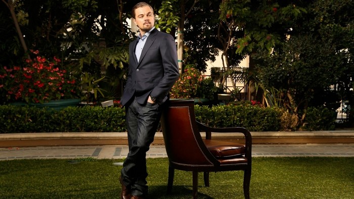 Leonardo DiCaprio posing in a garden with a chair
