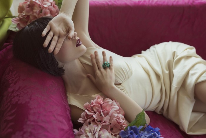Woman in a cream dress with a ring on her finger