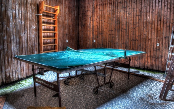 Abandoned room with ping pong table and ladder
