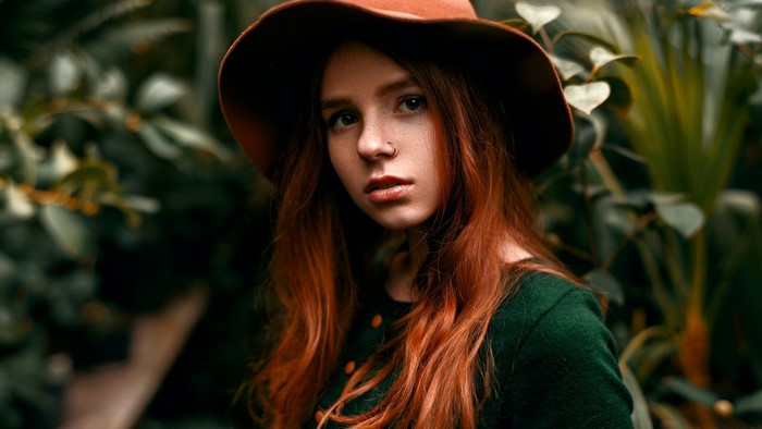 Redhead woman wearing a hat and green top