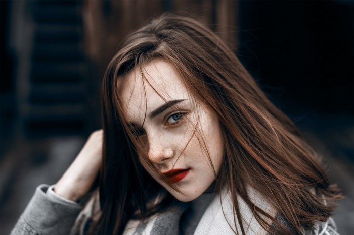 Woman with brown hair and freckles wearing red lipstick