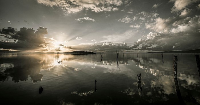 Sunset over a calm lake with dramatic clouds and reflections