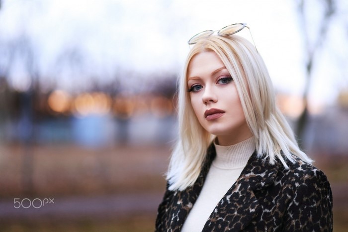 Blonde woman with glasses and leopard print coat