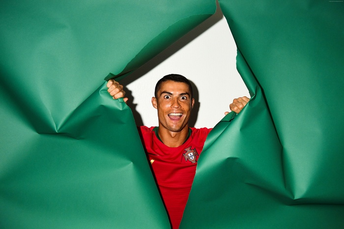 Cristiano Ronaldo peeking through green paper