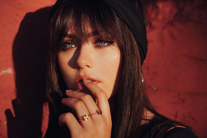Woman with bangs and blue eyes wearing a black headband