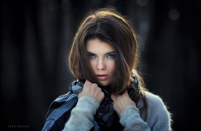 Woman with blue eyes wearing a scarf and sweater
