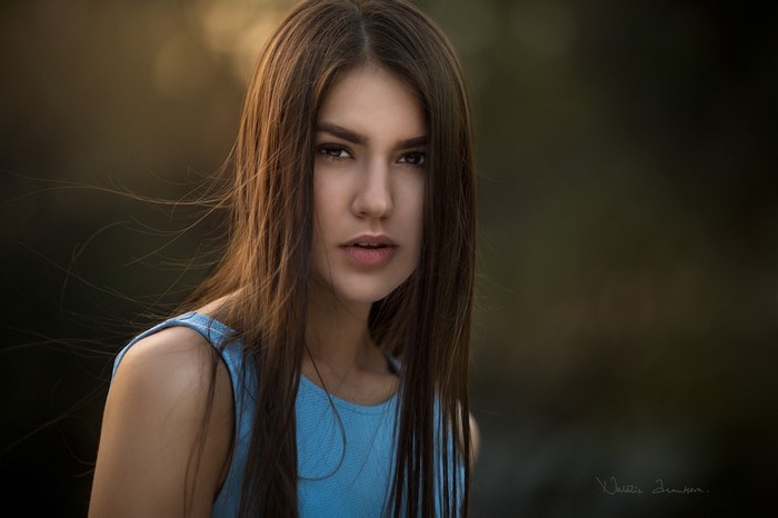 Woman with long brown hair in a blue dress